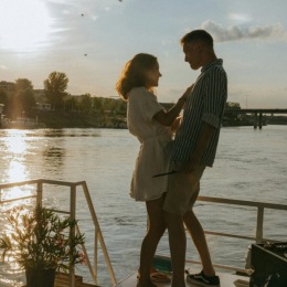 a couple dancing on a dock by a body of water